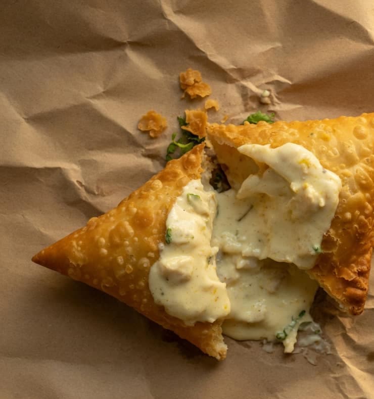 Malai chicken samosa opened to a pale creamy filling.